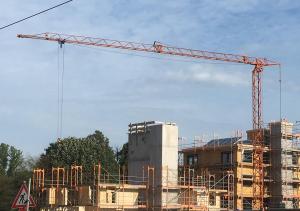 Baustelle mit Kran und halb fertig gebaute Mehrfamilienhäuser